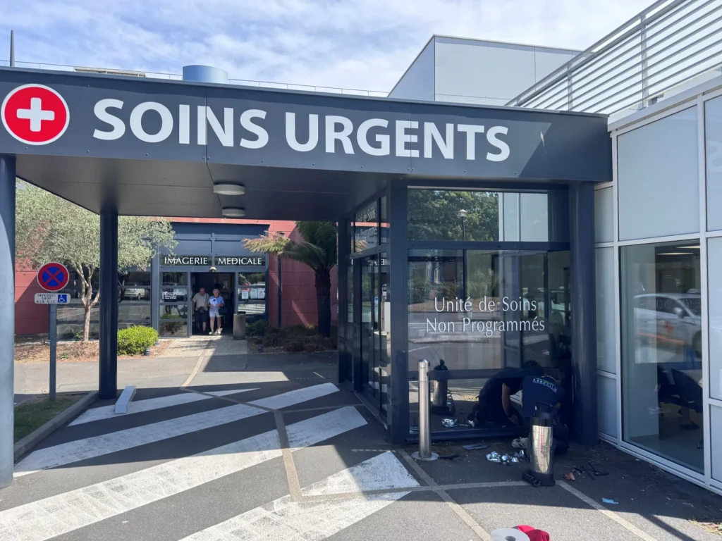 Poseur Easy Film appliquant un film solaire sur les vitrages de l’unité de soins non programmés, à l’entrée des soins urgents de l’Hôpital privé de la Baie à Avranches